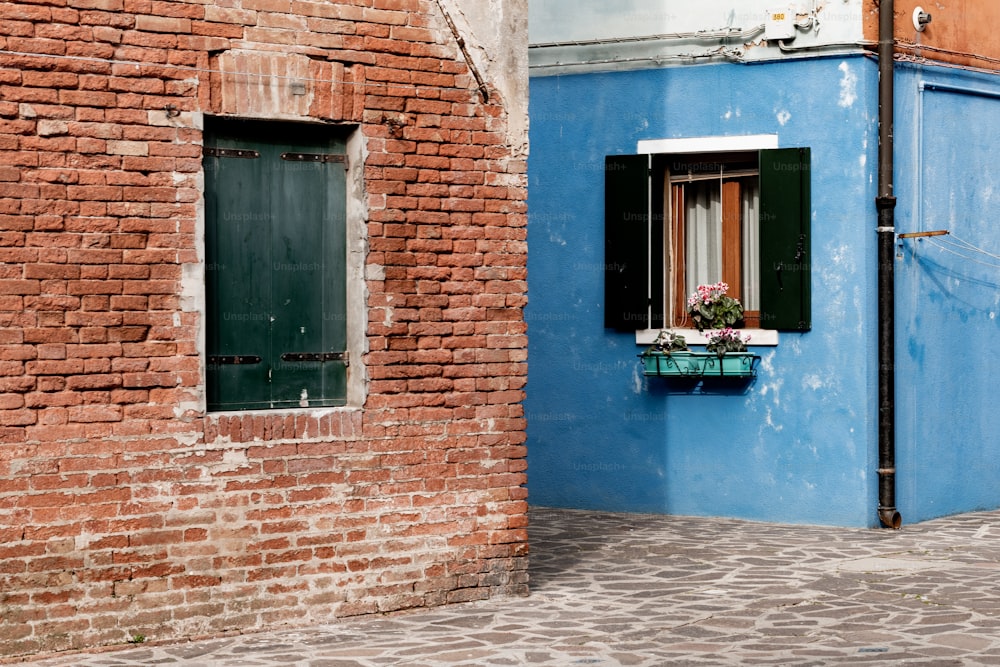 a blue building with a window and a brick wall