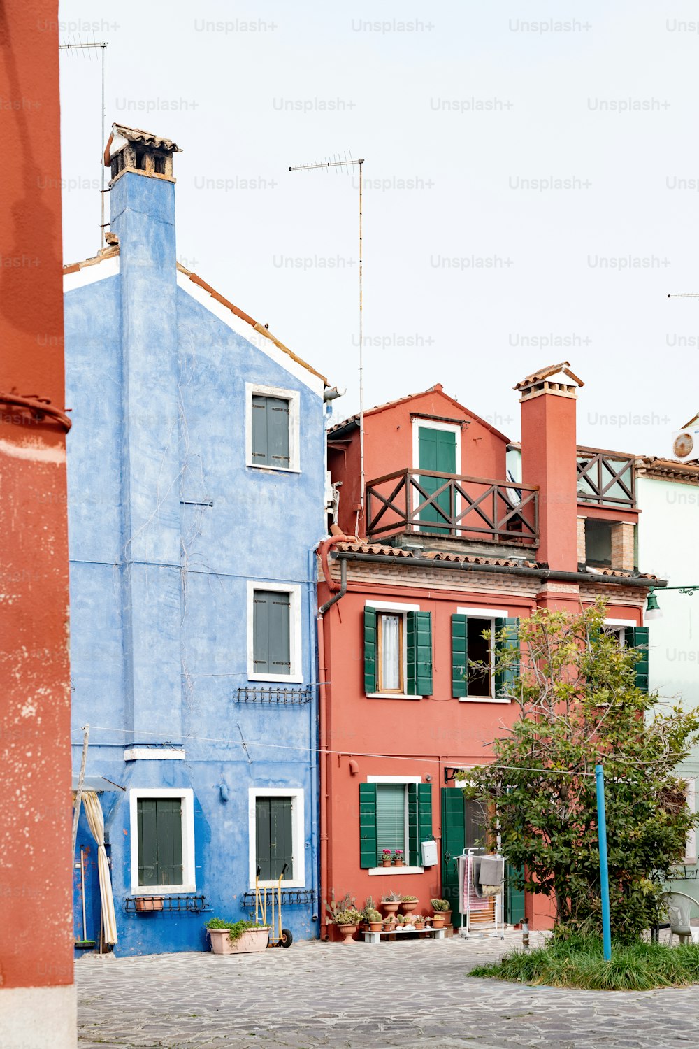 a blue and red building next to a tree