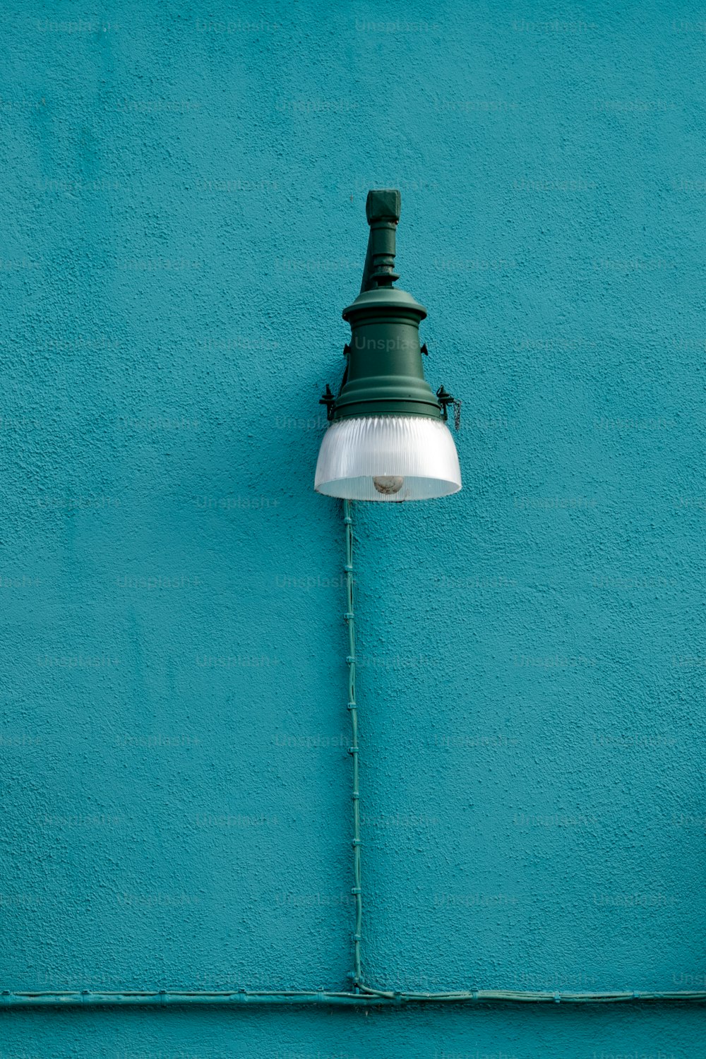 a green and white lamp on a blue wall