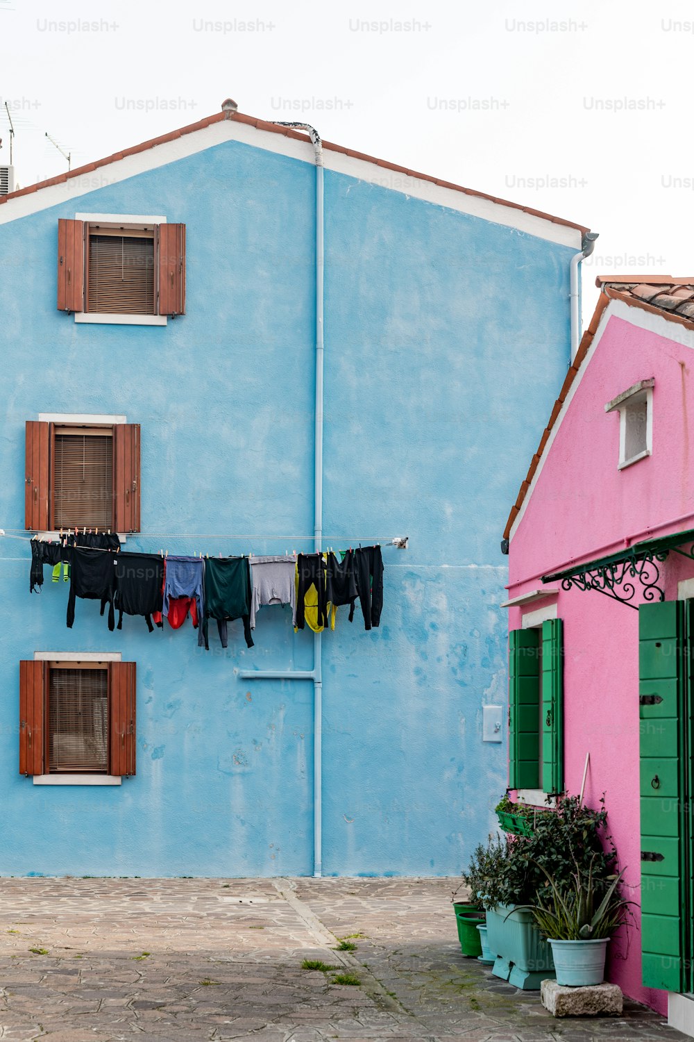 clothes hanging out to dry on a clothes line in front of a blue building