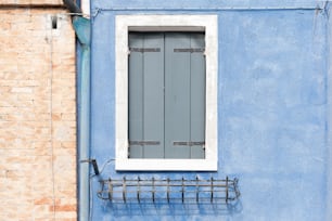 a blue building with a window and a coat rack
