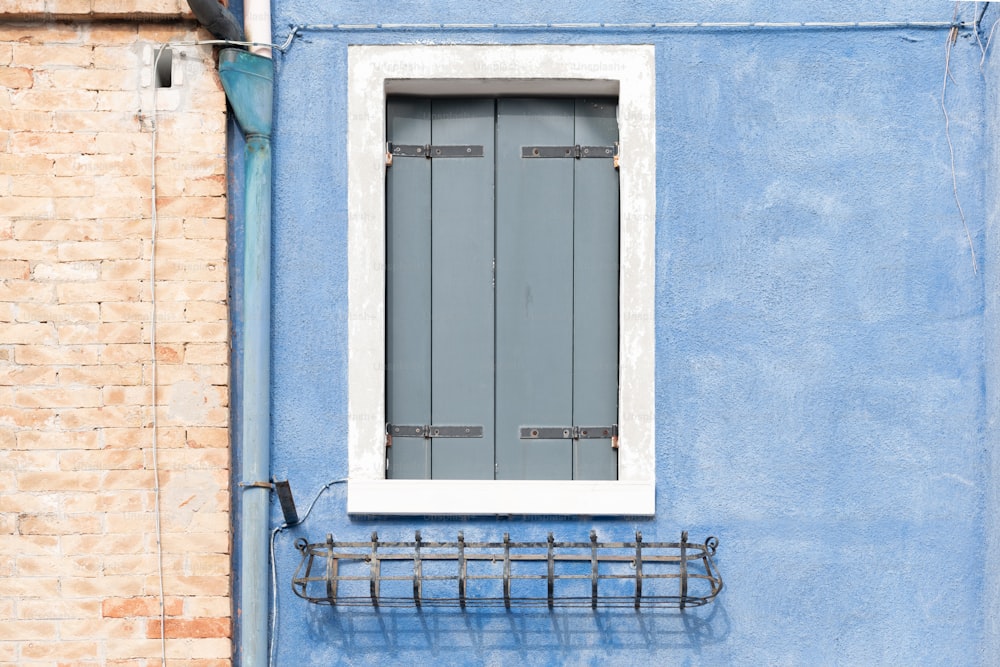 Un edificio azul con una ventana y un perchero