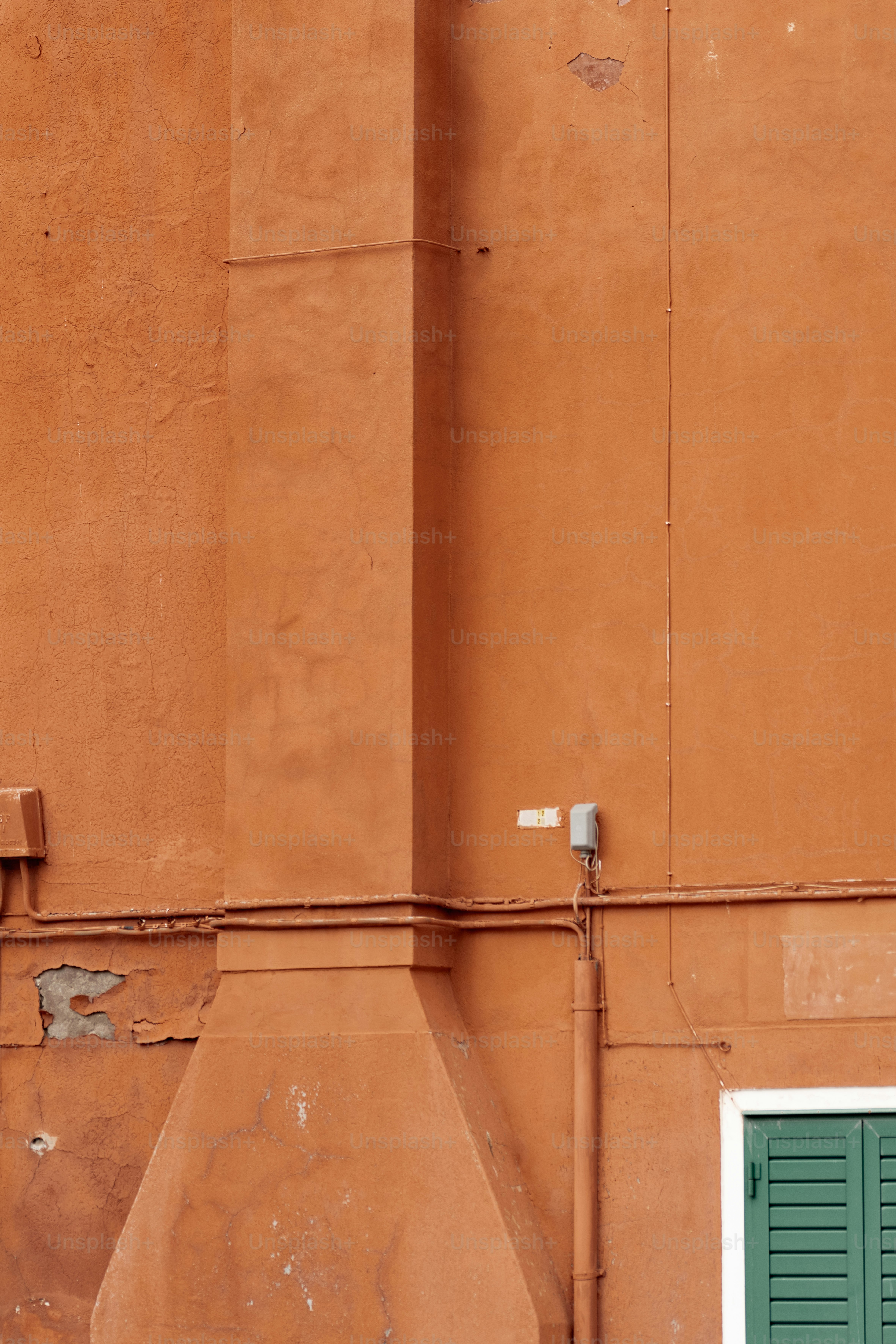 Un edificio naranja con una puerta y ventana verde