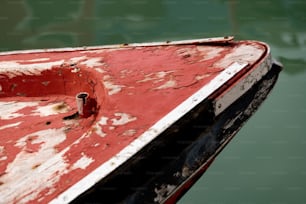a red and white boat sitting on top of a body of water