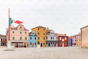 a row of colorful buildings with a flag on top