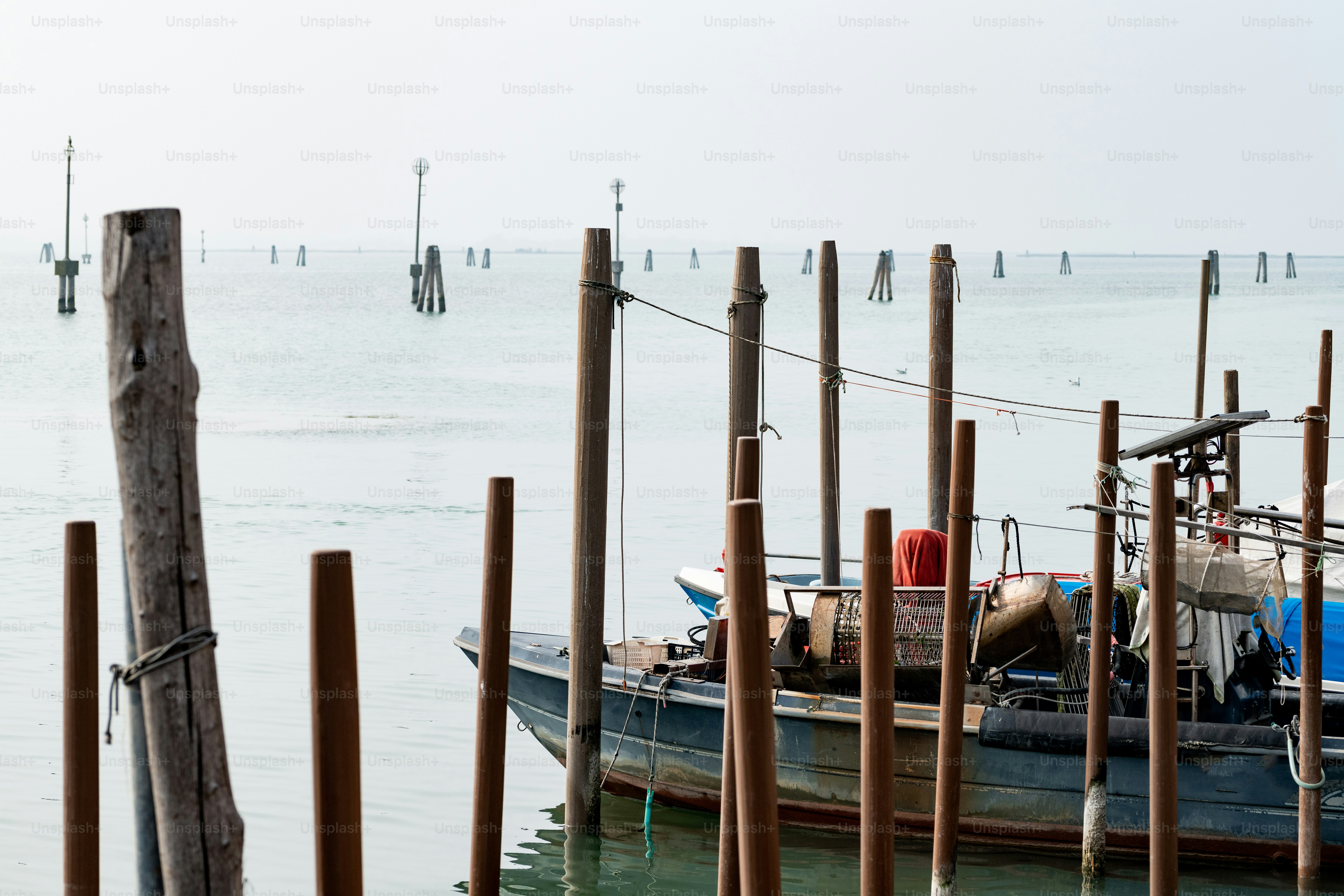 Un bateau est amarré dans l’eau près de poteaux