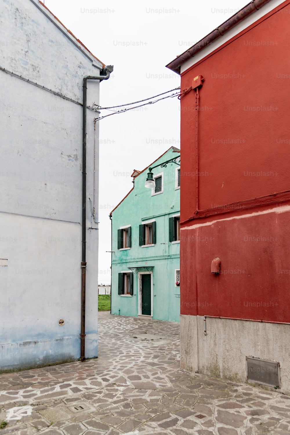 ein rot-blaues Gebäude neben einem weißen Gebäude