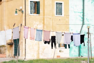 roupas penduradas para secar na frente de um prédio