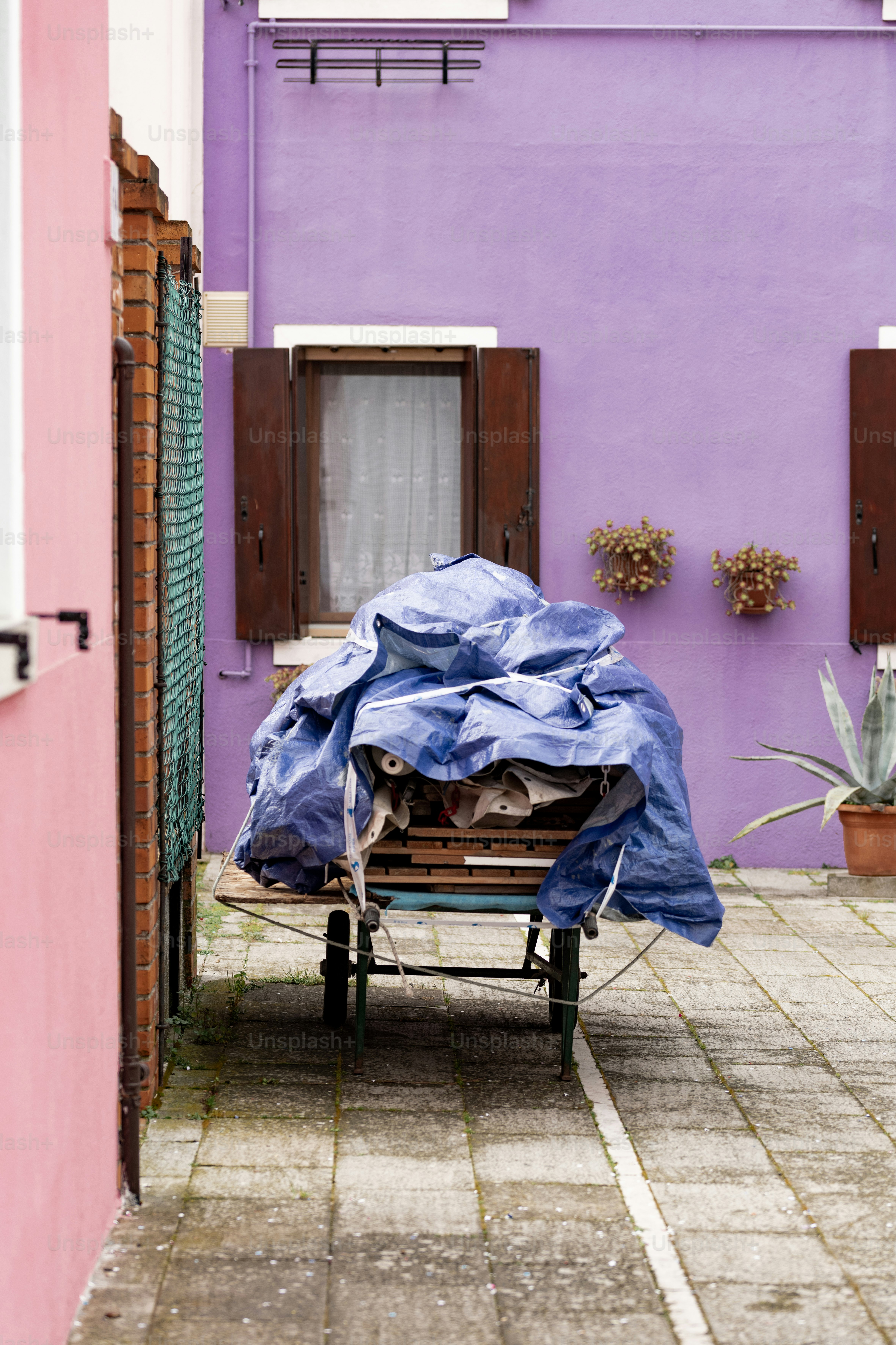 un bâtiment violet recouvert d’une bâche bleue