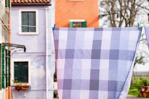 a blue and white checkered cloth hanging from a clothes line