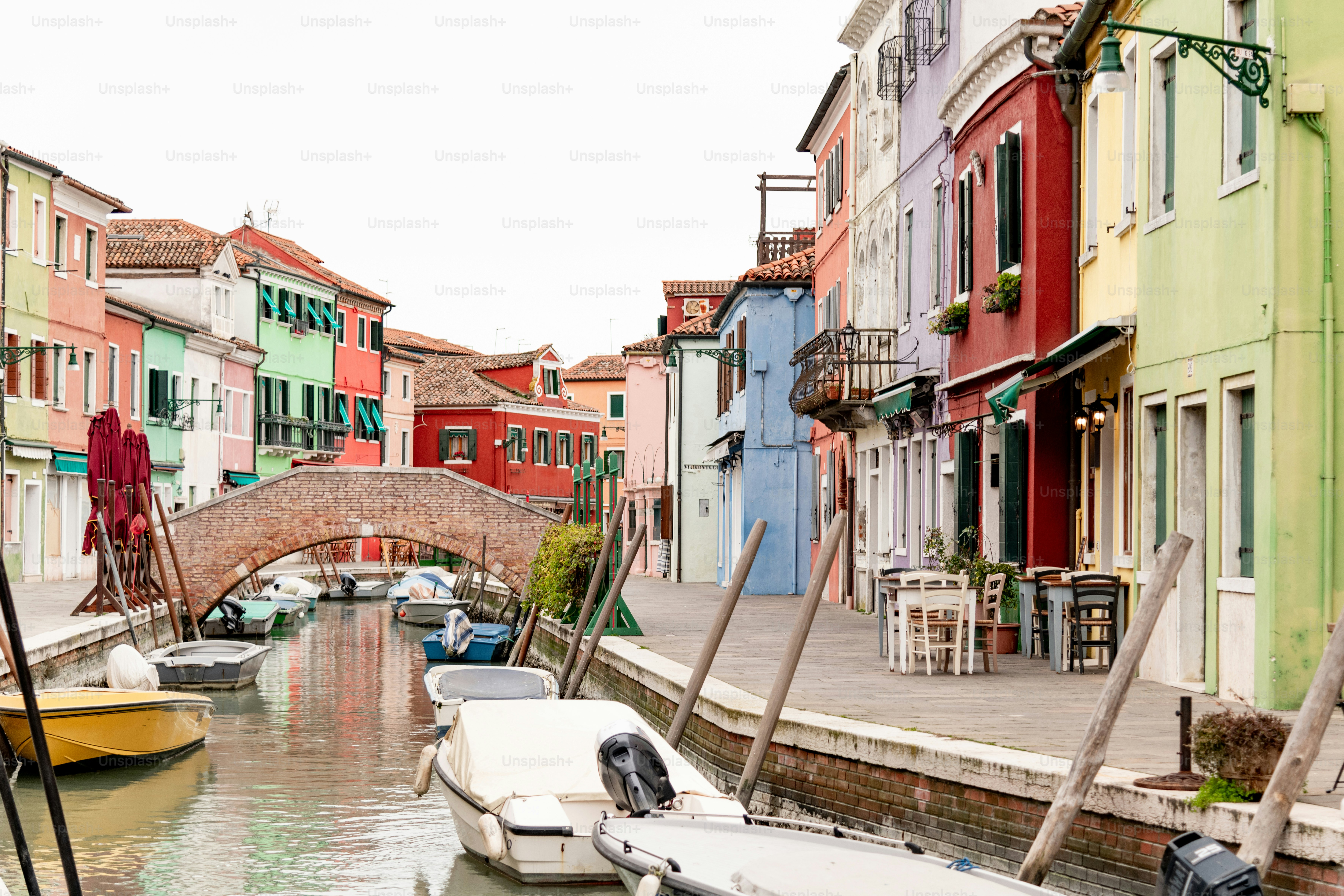a canal with boats and a bridge in the background