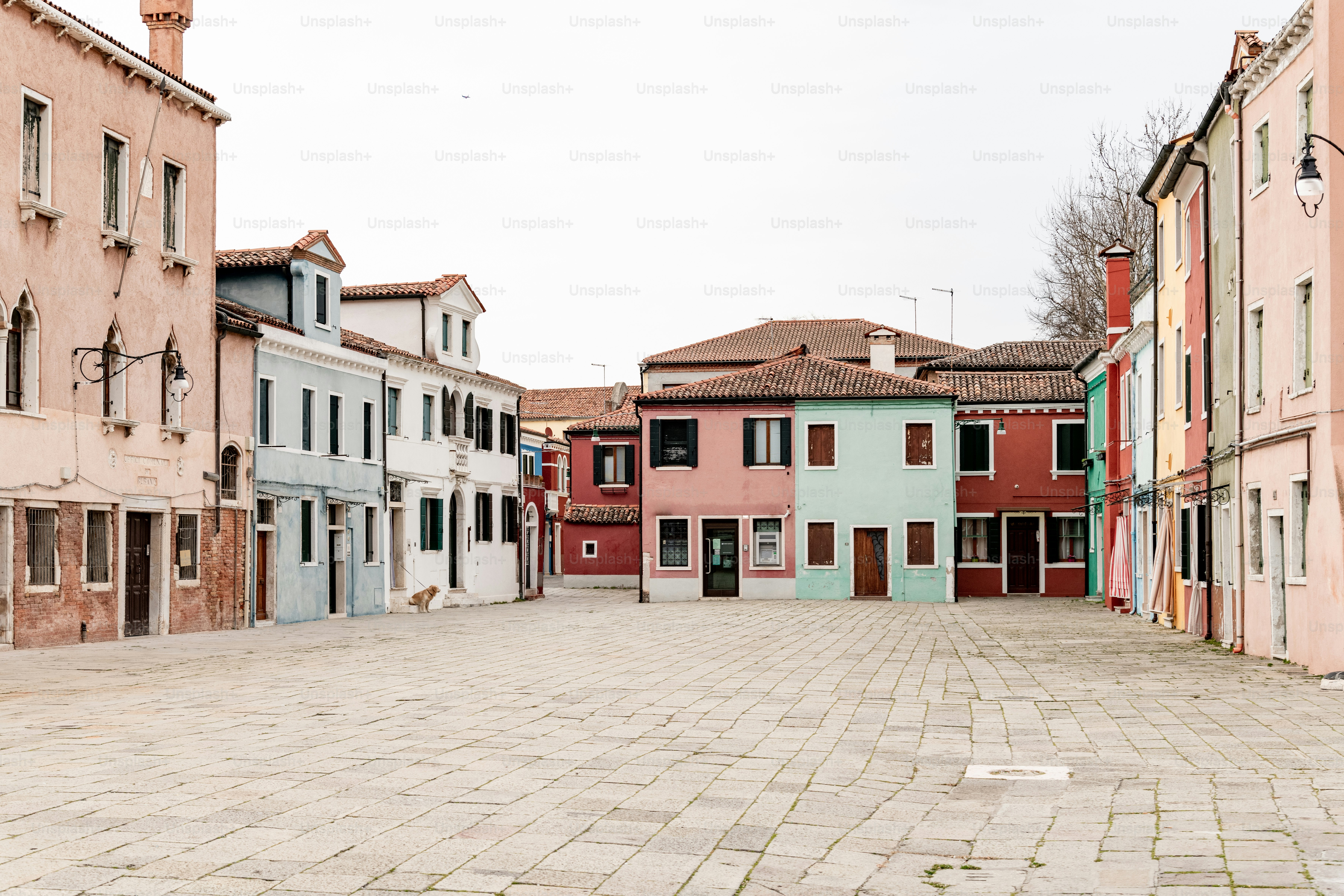 a cobblestone street lined with buildings and a clock tower