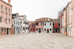 a cobblestone street lined with buildings and a clock tower