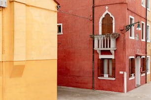 a red building with a balcony and a window
