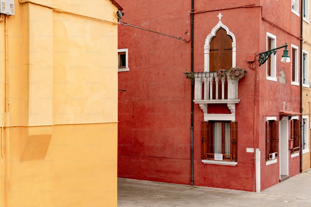 a red building with a balcony and a window