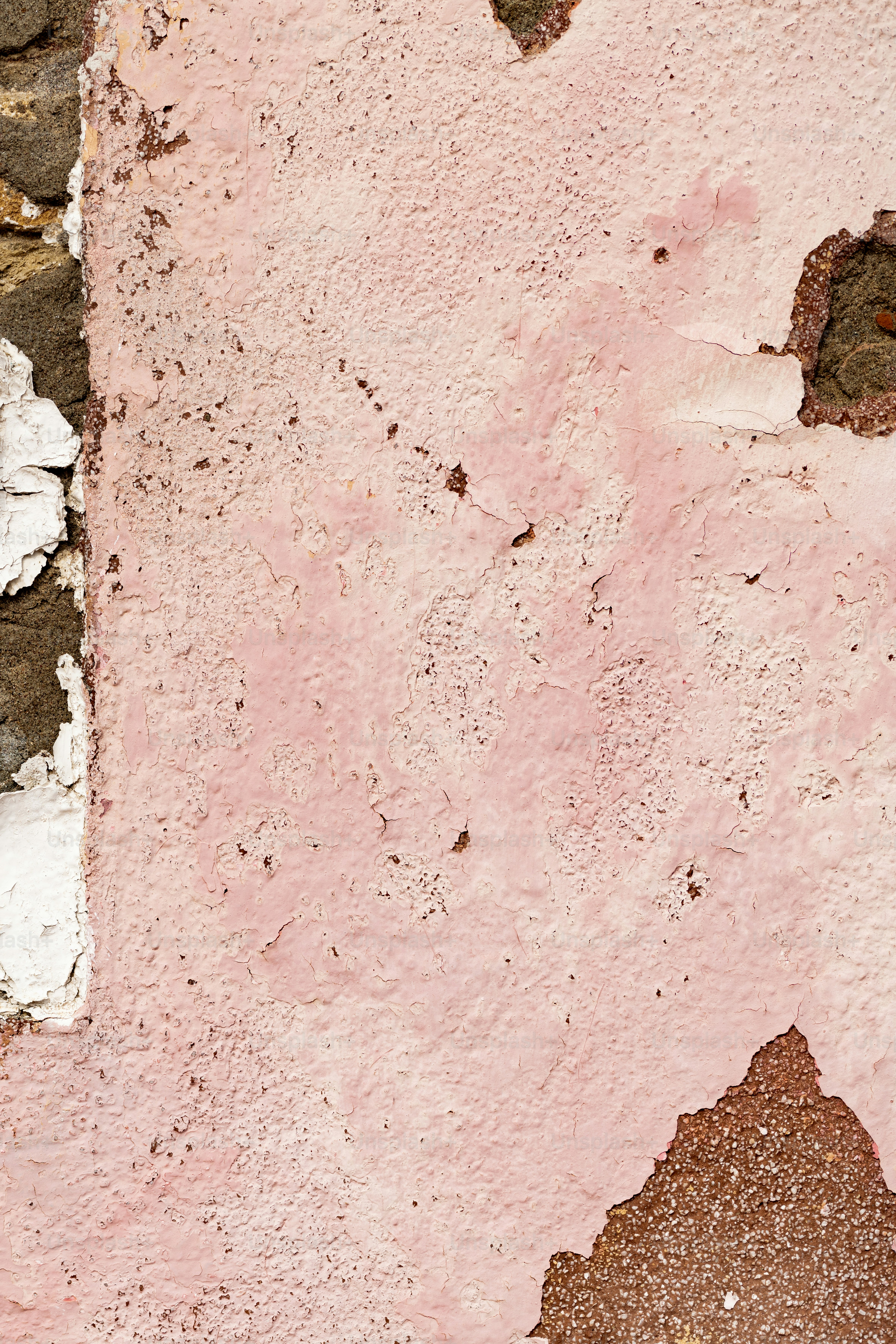 Una boca de incendios roja sentada junto a una pared rosa