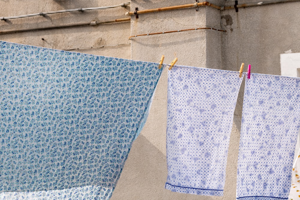 two blue towels hanging on a clothes line