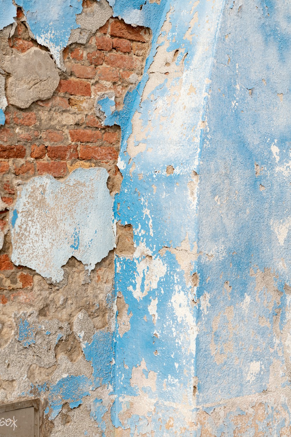 una pared de ladrillo con pintura descascarada