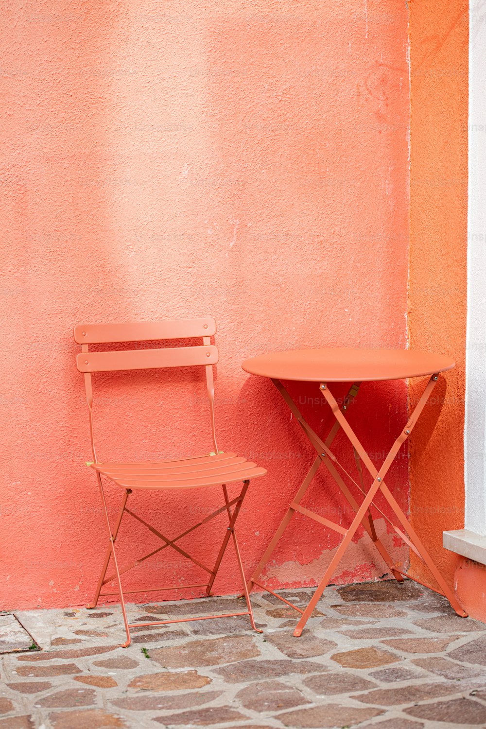 a chair and a table against a pink wall