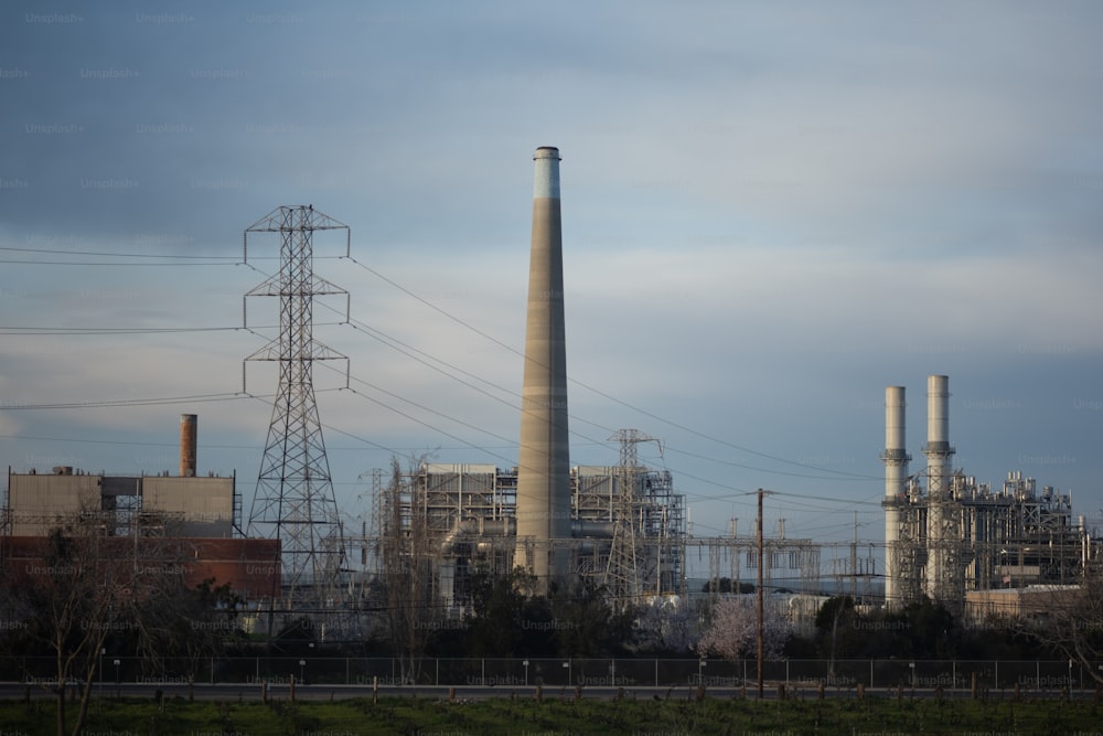 a factory with smoke stacks and power lines