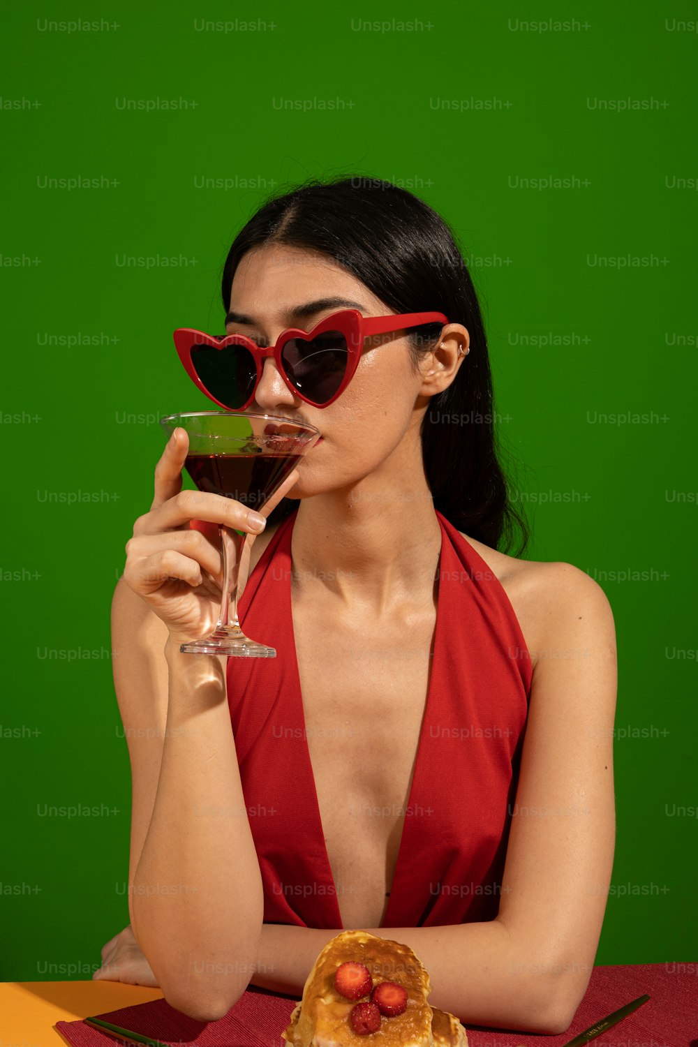 a woman in a red dress holding a glass of wine