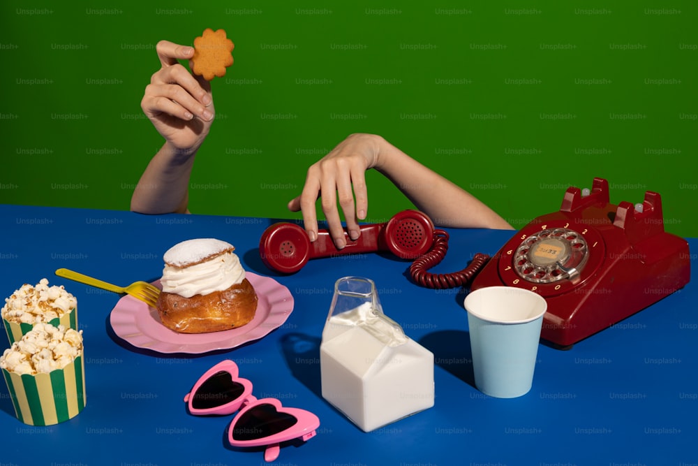 Eine Frau sitzt an einem Tisch mit einem Telefon, einer Tasse Kaffee, einem
