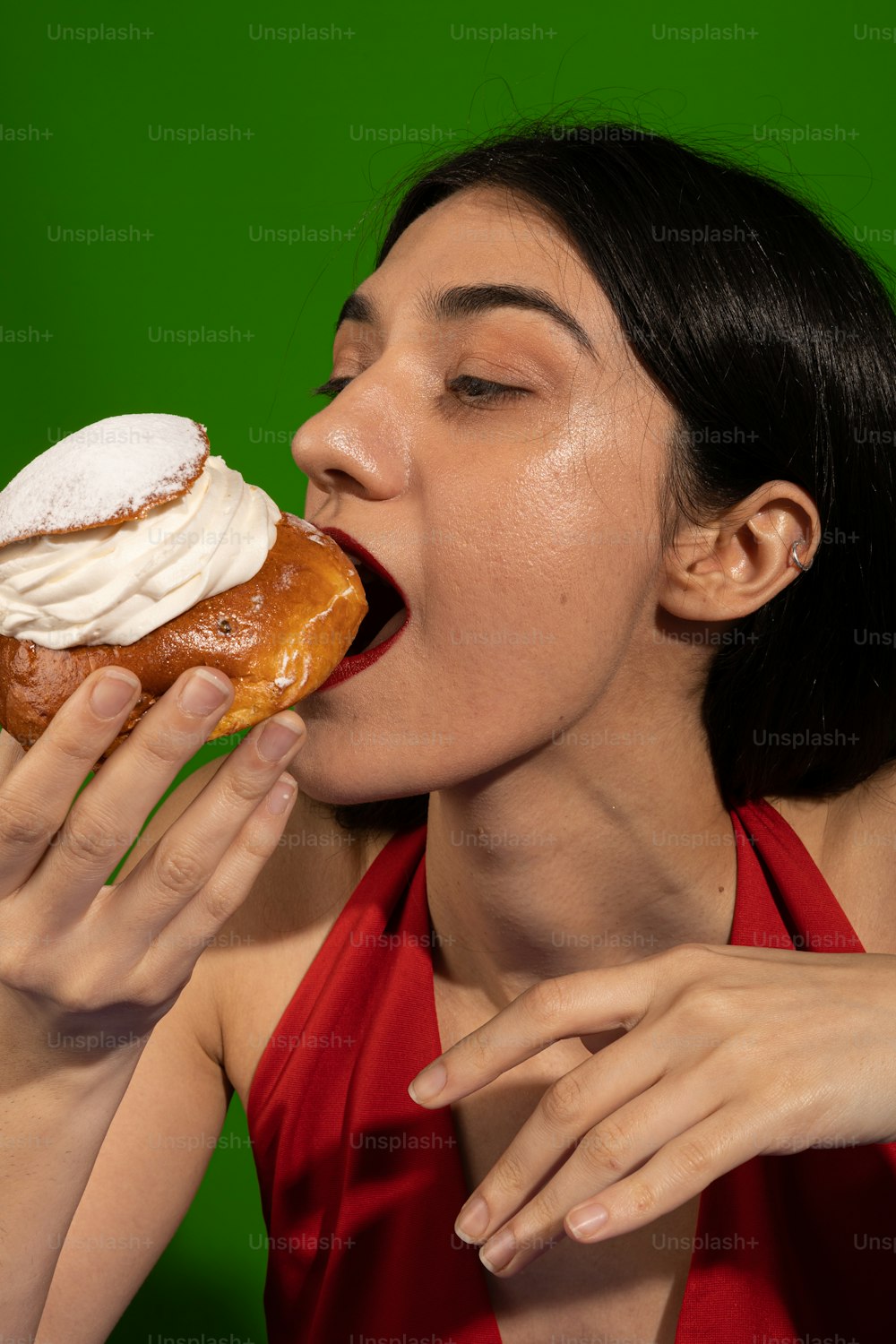 a woman in a red dress eating a donut