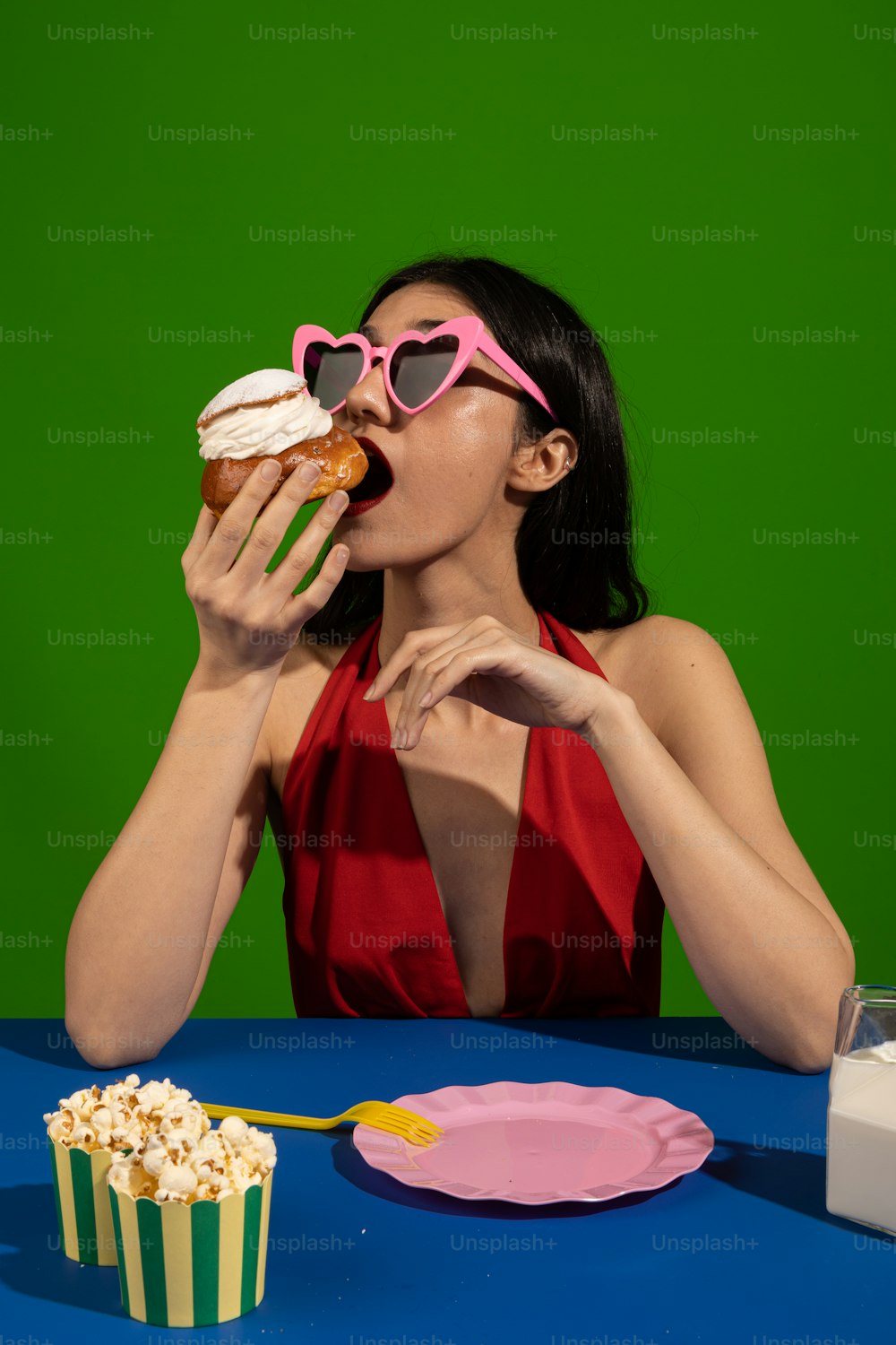 빨간 드레스를 입��은 여자가 컵케이크를 먹고 있다