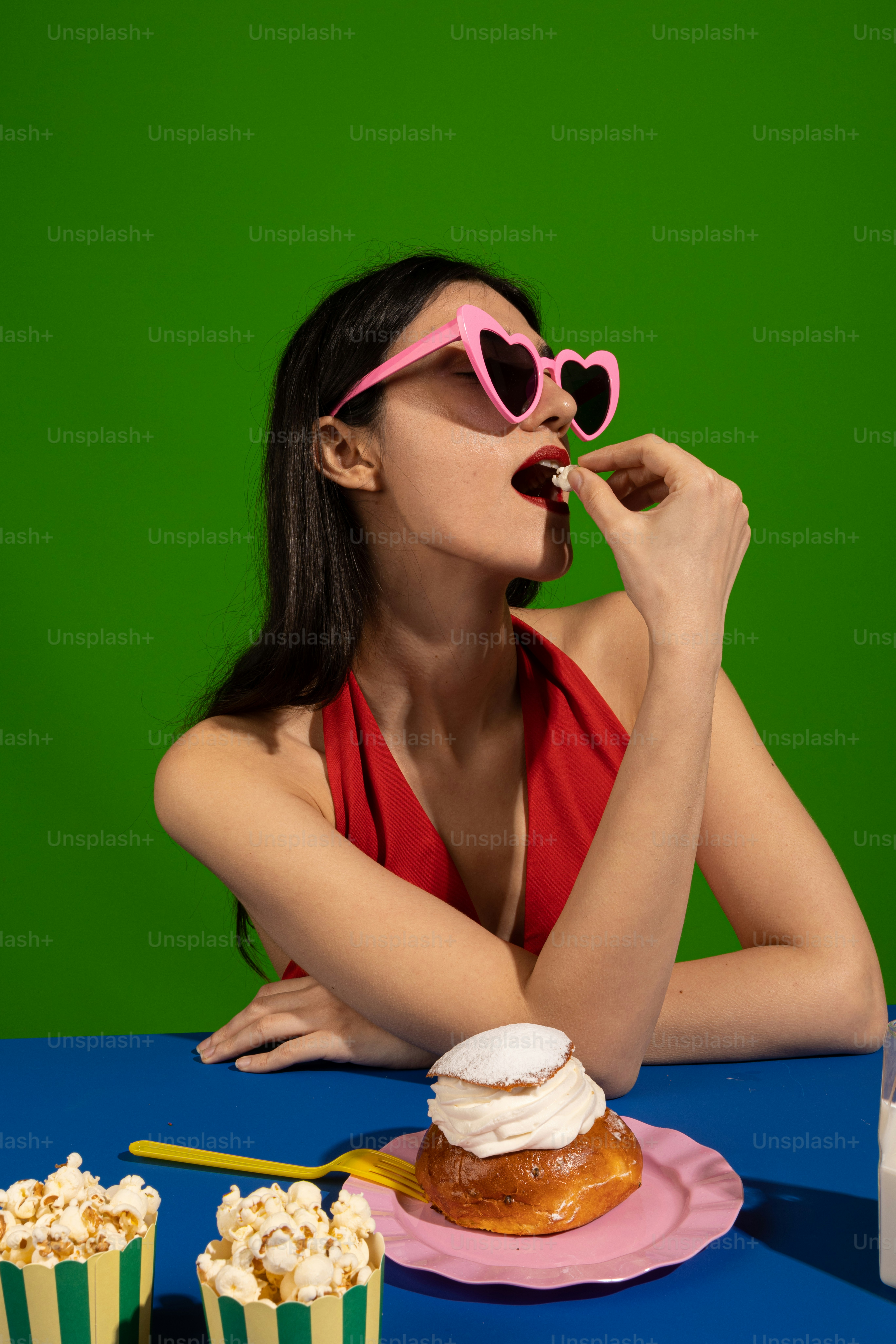 a woman in a red top is eating a donut