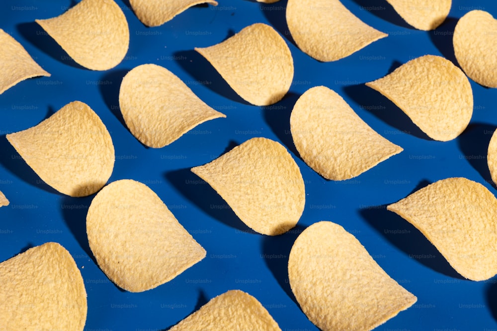 a bunch of tortilla chips on a blue surface
