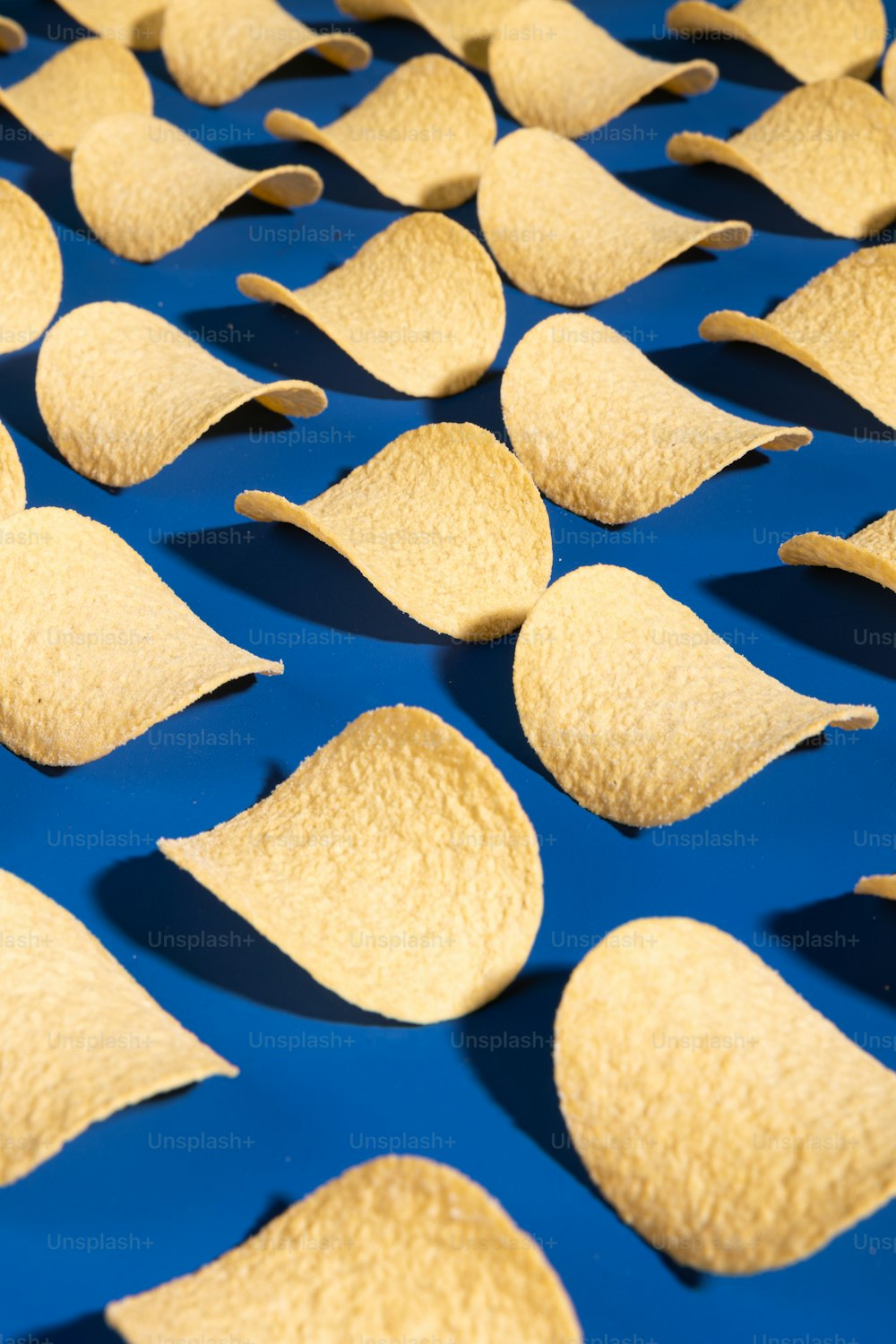 tortilla chips are arranged on a blue surface