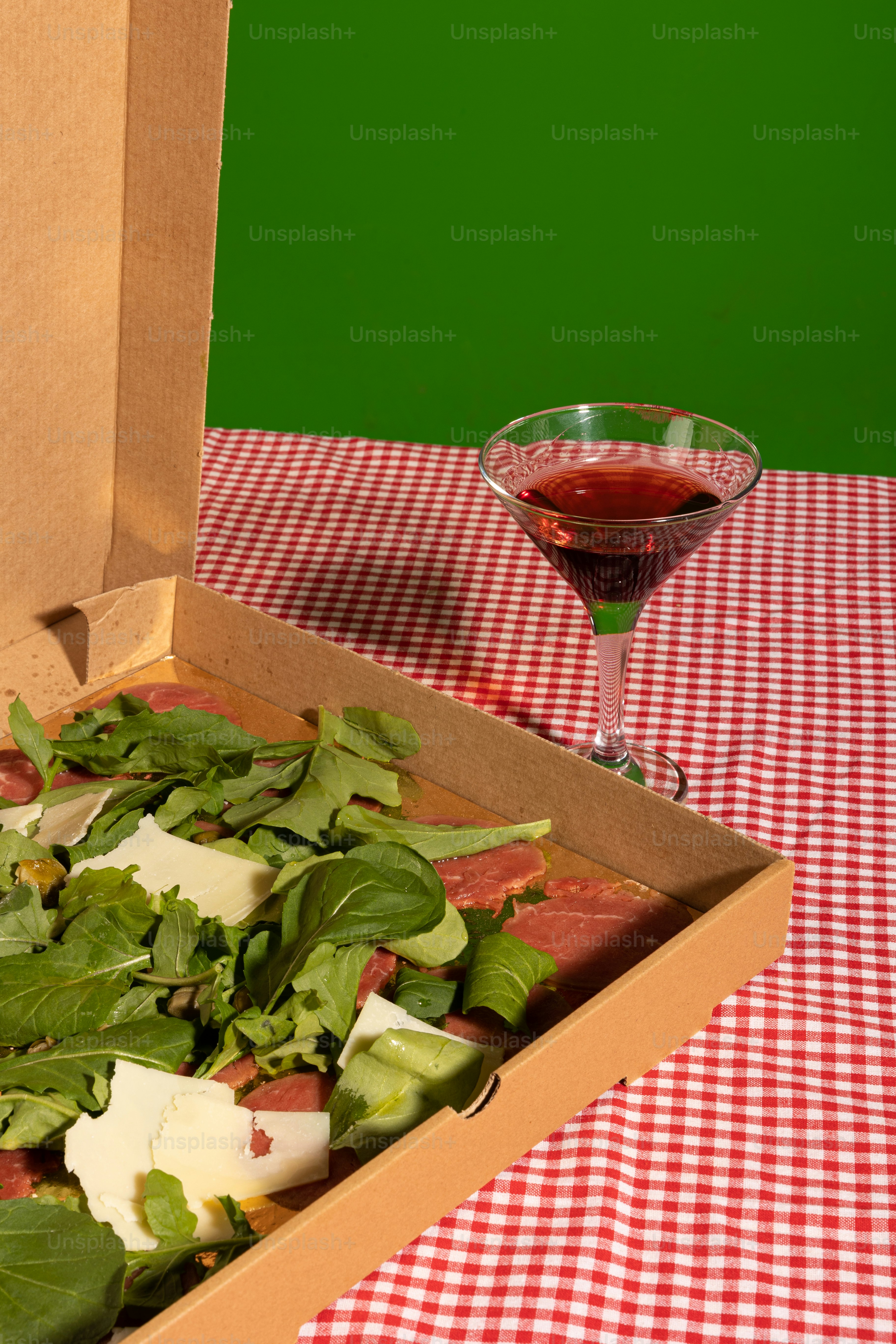 a box of food and a glass of wine on a table