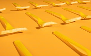 a group of yellow toothbrushes laying on top of each other
