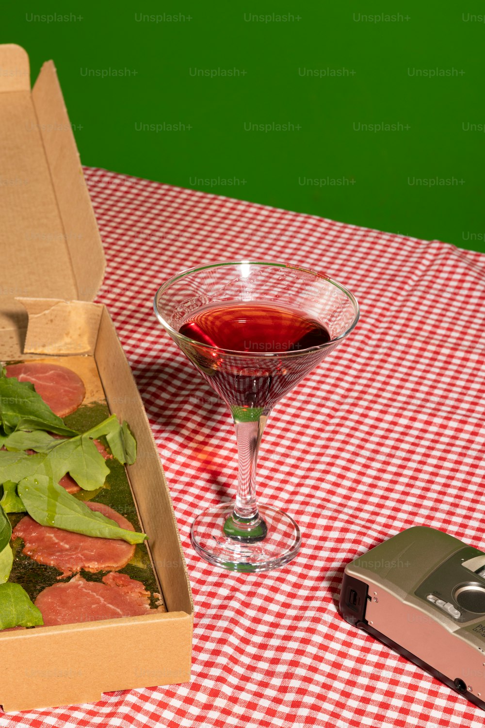 a box of pizza and a glass of wine on a table