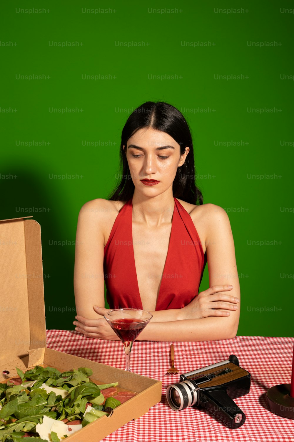 a woman sitting at a table with a box of pizza