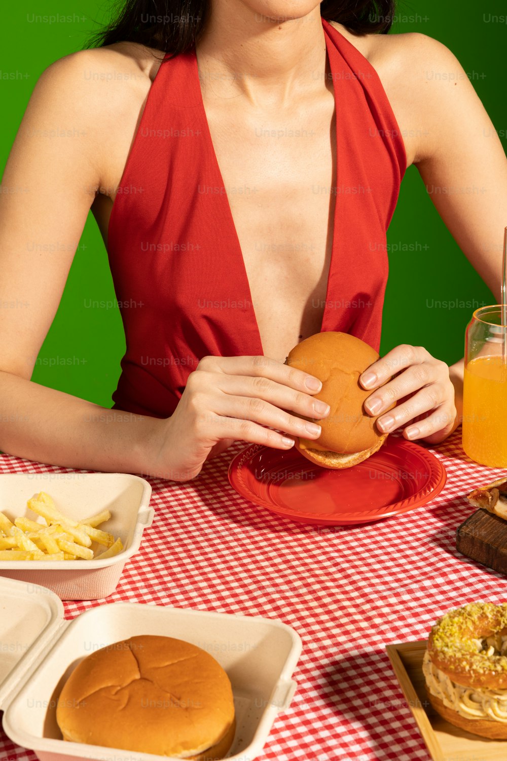 a woman sitting at a table with a hamburger and french fries