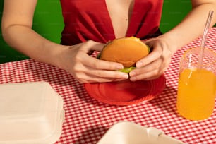 a woman in a red dress is holding a hamburger
