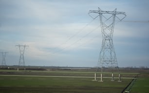 ein paar Stromleitungen, die sich auf einem Feld befinden