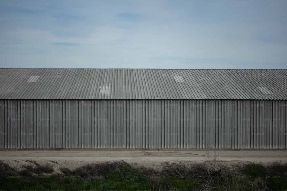 a large metal building sitting next to a lush green field