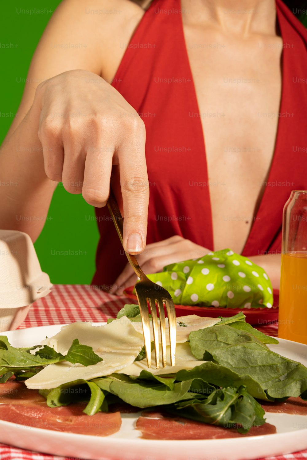 Une femme en robe rouge mange une salade