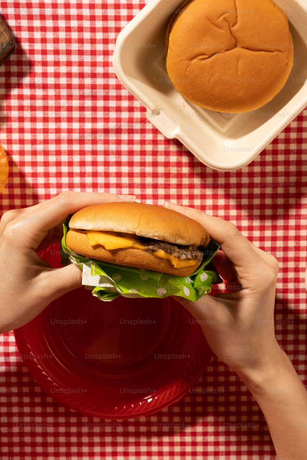 a person holding a hamburger in their hands