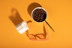 a bowl of cereal and a pair of glasses on a yellow surface