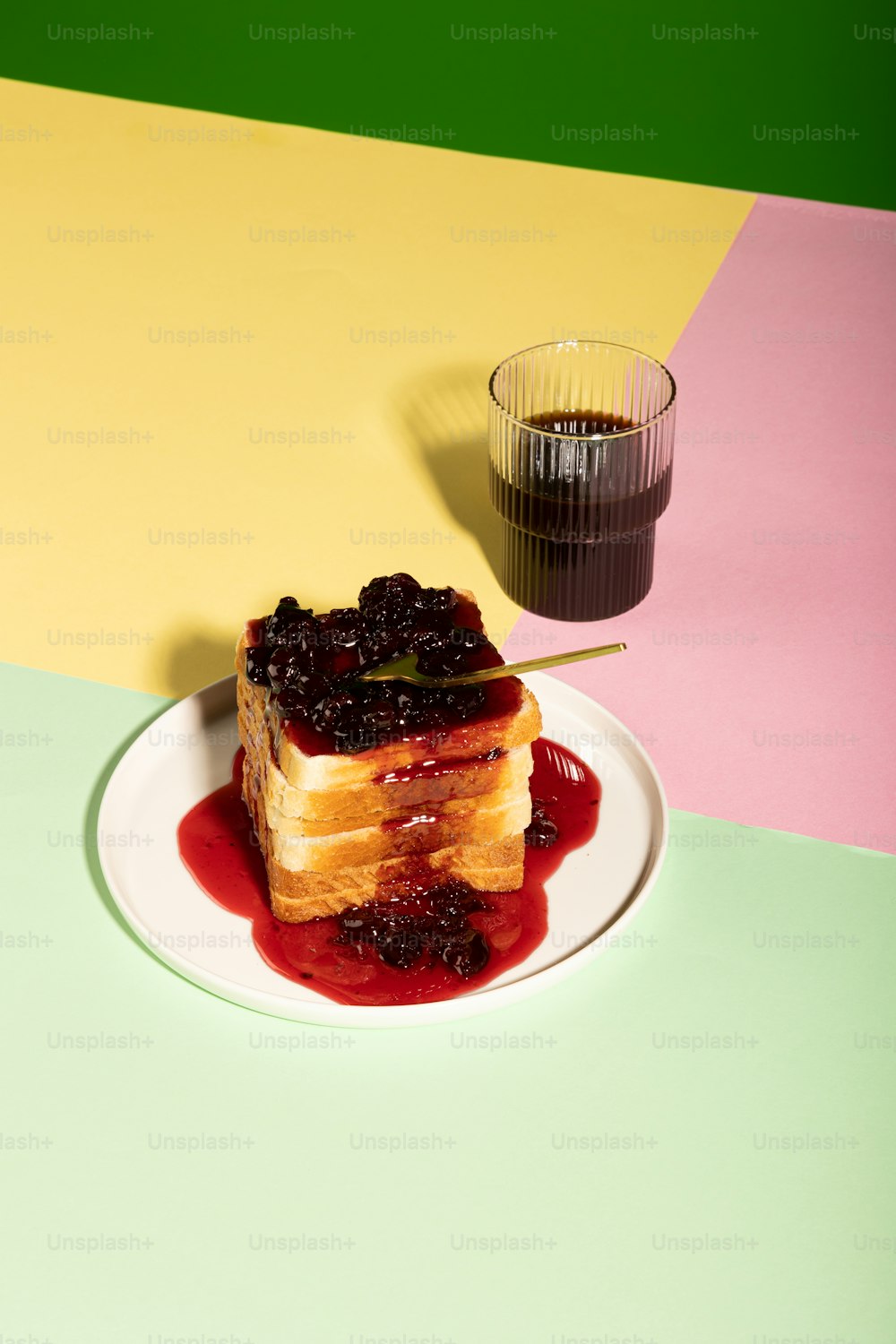 a white plate topped with a piece of cake covered in fruit