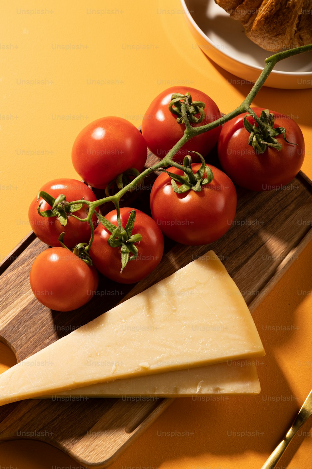 a wooden cutting board topped with tomatoes and cheese