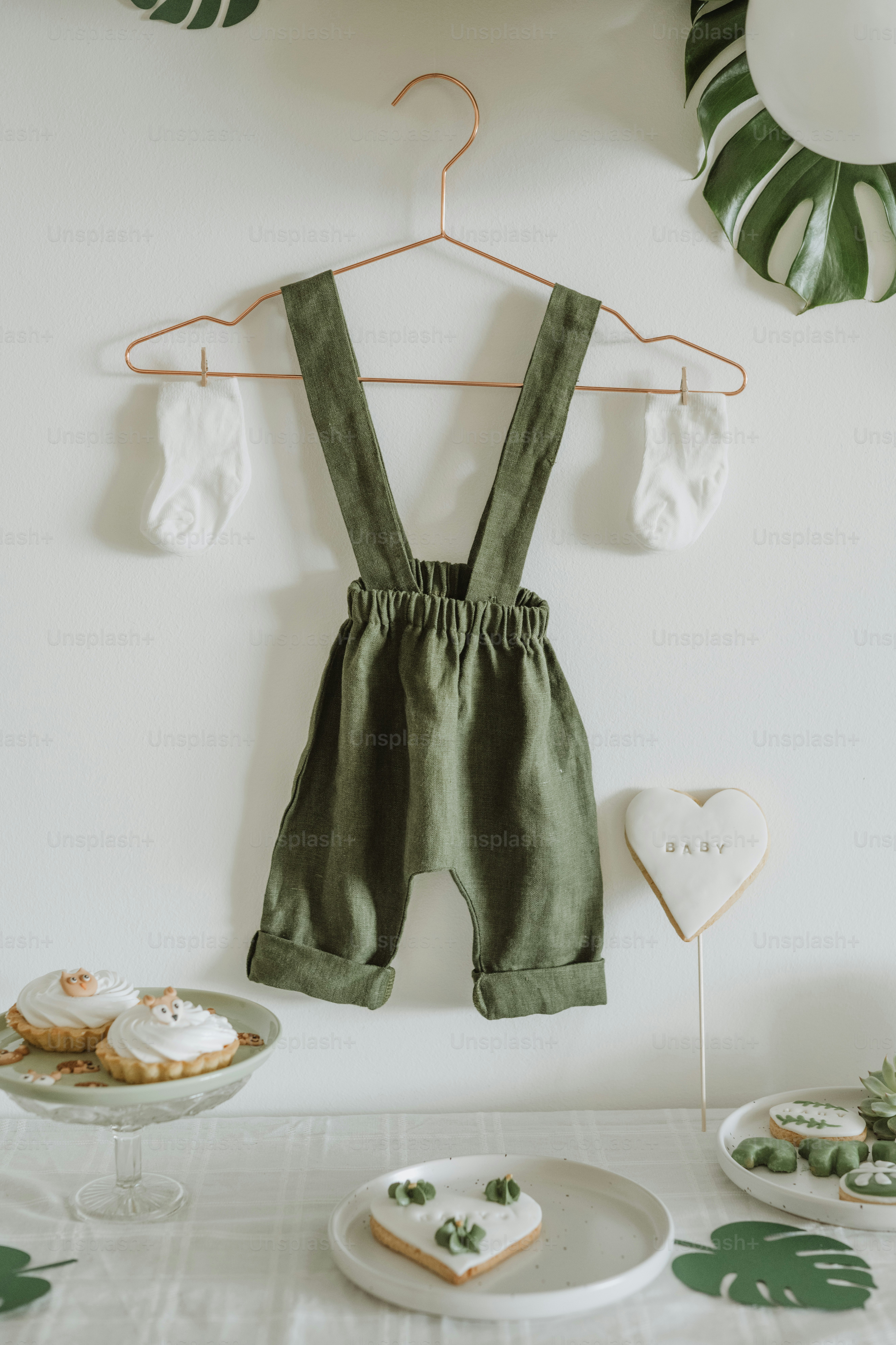 a white table topped with a plate of food and a green bib