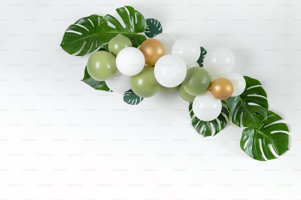 a bunch of balloons with green leaves on them