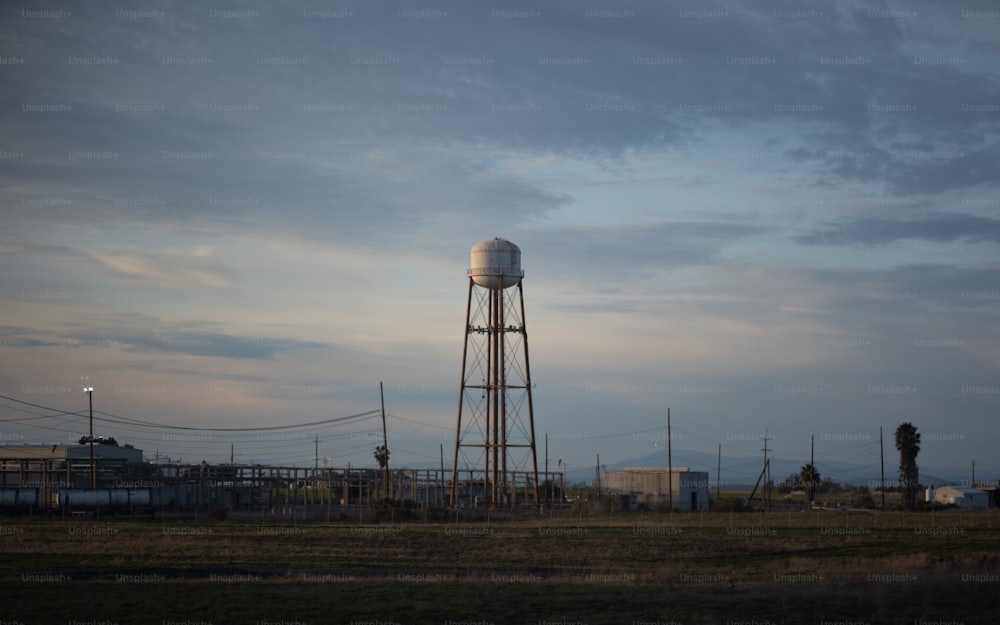 a tall water tower sitting in the middle of a field