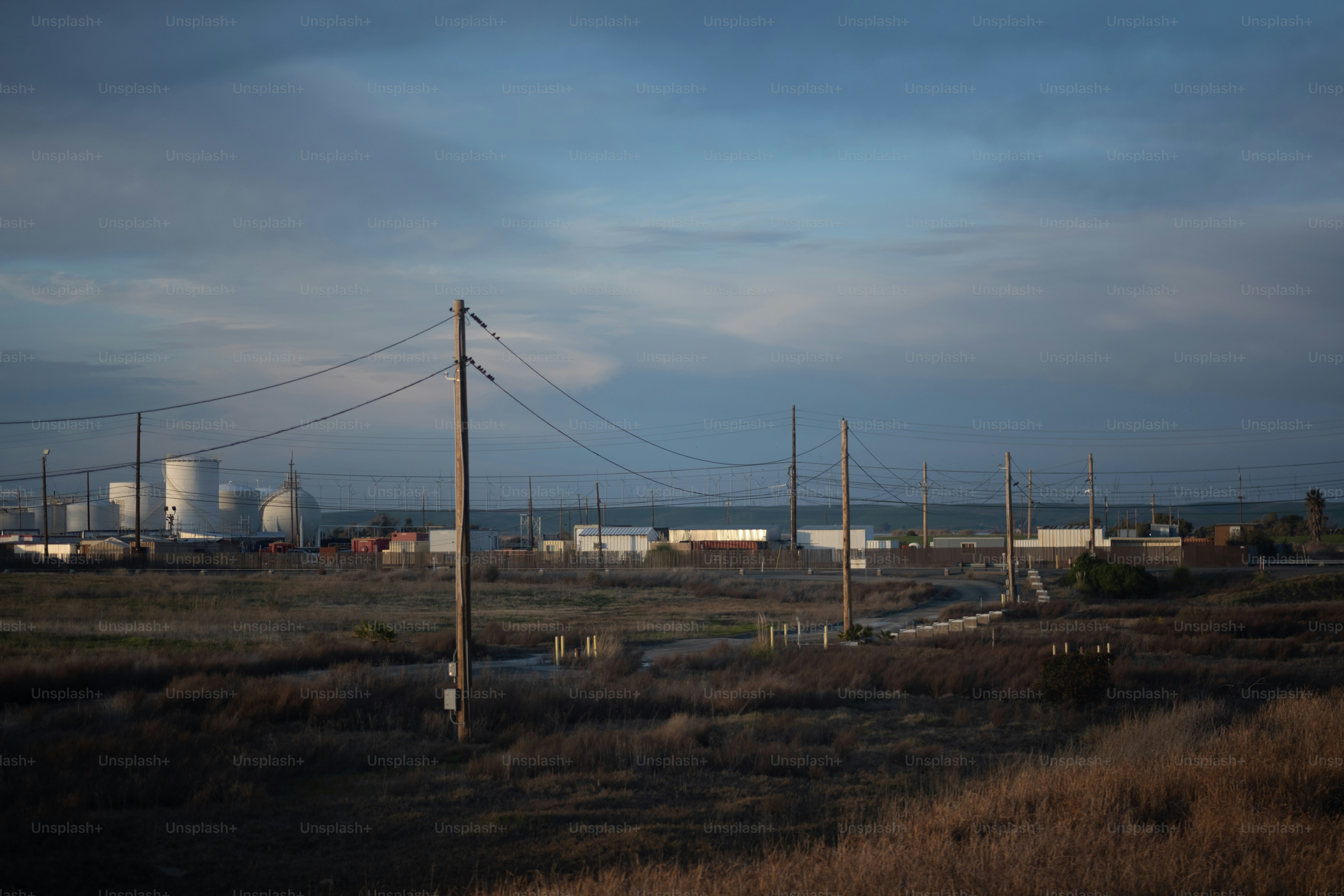 a view of a field with power lines in the foreground