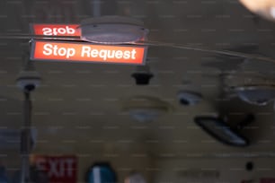 a red sign that says stop request hanging from a ceiling