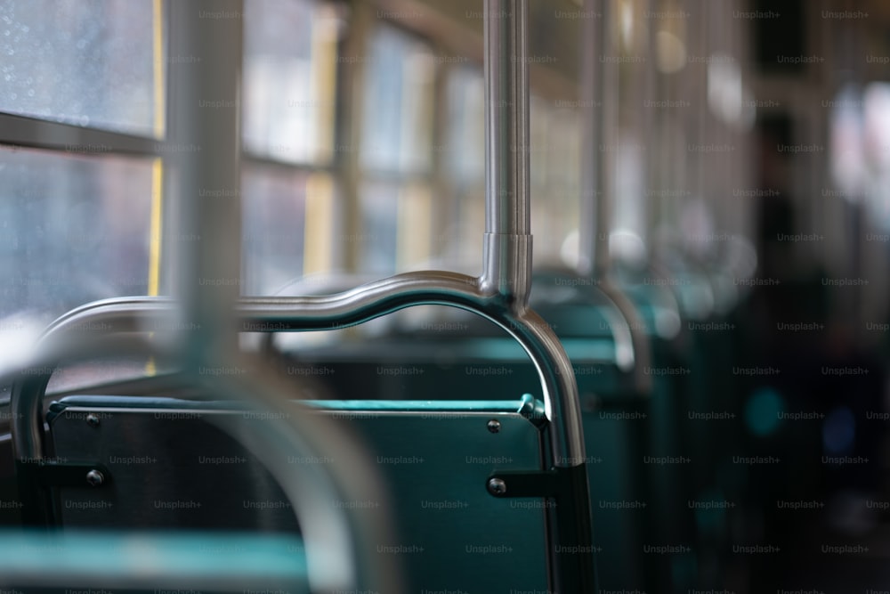 uma fileira de assentos verdes vazios em um ônibus